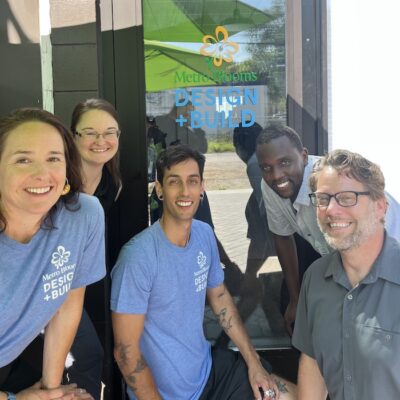 5 people standing in front of door with Metro Blooms D+B logo